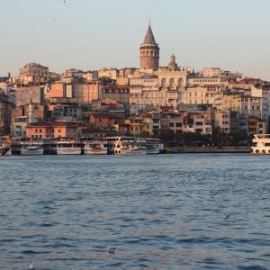 A breathtaking view of the Galata Tower and Istanbul's vibrant waterfront at sunset.