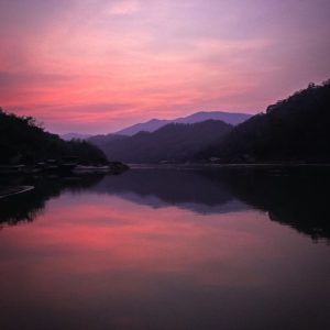 Serene sunset view with vibrant colors reflecting on a calm river in Laos.